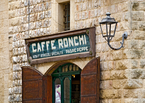 old name plate over the entrance to a coffee house at Altamura, Italy