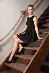 Pretty brunette woman siting on wooden stairs