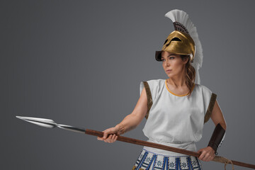 Shot of antique greek fighter woman with golden helmet and spear.