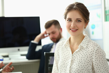 Business lady with positive look and cheerful smile poses for camera