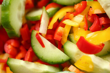 Top view macro sliced cucumber red and yellow peppers