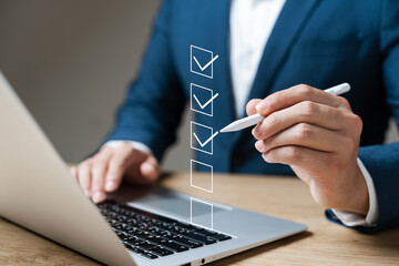 Business performance checklist concept, businessman using laptop doing online checklist survey, filling out digital form checklist. - obrazy, fototapety, plakaty