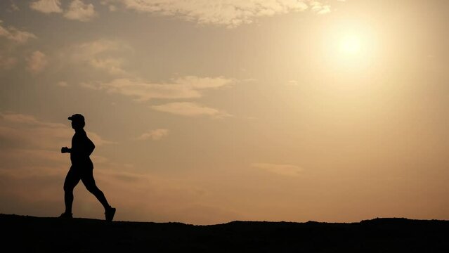 Silhouette of man running freely happy in beautiful evening light