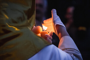 nazareno with candle illuminating the procession on the night of holy friday - obrazy, fototapety, plakaty