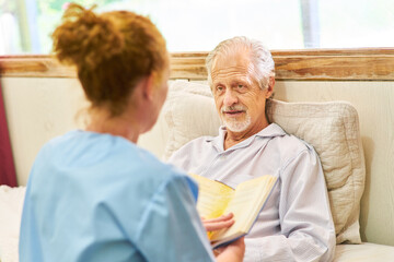 Woman from the nursing service reads from a book
