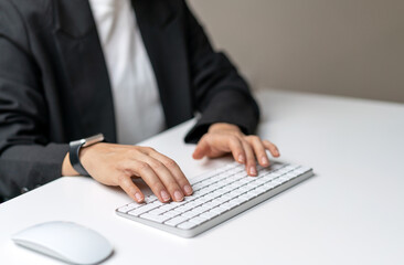 Female hands typing on wireless computer keyboard.