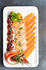 Assorted fish slices in a plate.
