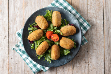 Traditional spanish fried croquettes on wooden table. Top view