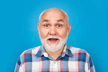 Middle aged surprised man on studio isolated background. Close up portrait of grey-haired mature senior man. Surprised old mature man face.