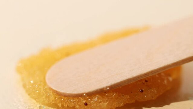 Orange particles of sugar scrub for peeling, skin cleansing. Close-up of a cosmetic product for spa treatments and massages.