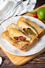 Pacanga pastry. Turkish cuisine delicacies. Pastry made with phyllo, tomato, green pepper, capia pepper, cheddar cheese and pastrami. Ramadan food. Local name paçanga boregi. Close up