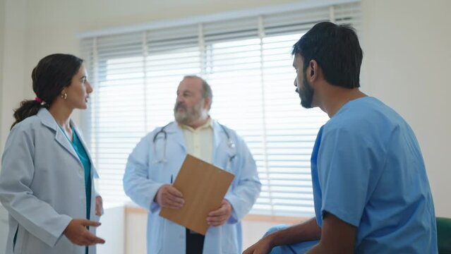 Professional woman doctor and asian senior male doctor talking and encourage an Indian male patient has been treated with doctor at the hospital