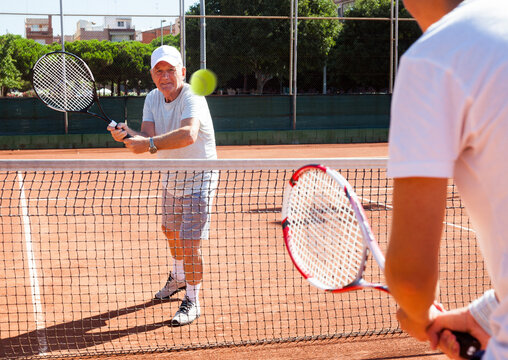 mature sportsman playing at tennis court
