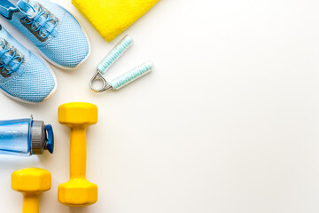 Sport background with sneakers and dumbbells, top view