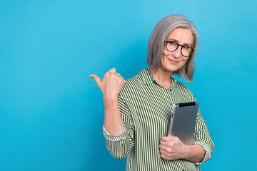 Photo of elderly pretty person hold tablet direct thumb finger empty space isolated on blue color...