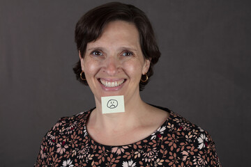Emotional Contradiction image. A woman with a smile secretly hides depression. 