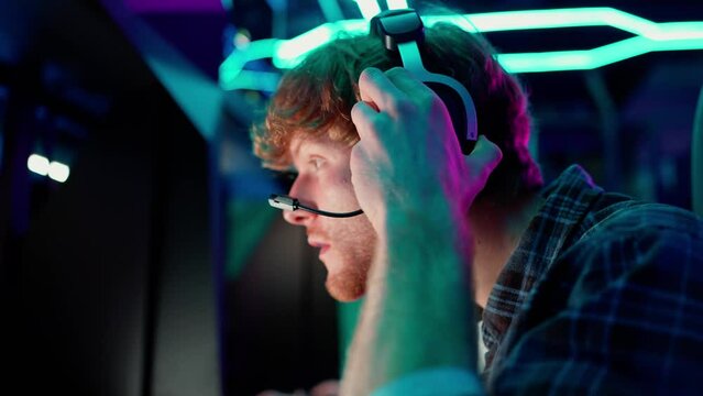 Happy ginger man gamer starts to play RPG video game on a championship. Stylish Neon Cyber Games