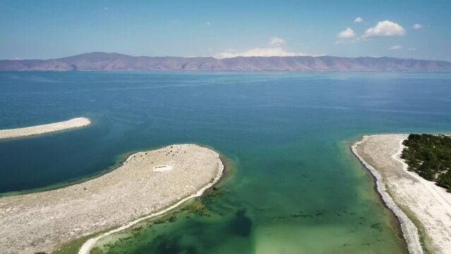Aerial shot of Seagulls Island in Sevak lake. Gorgeous summer landscape with the lake and mountains