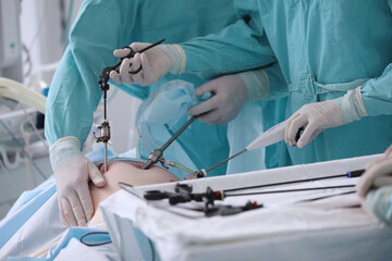 Abdominal surgery. Laparoscopy in surgery. Surgical intervention through small holes. Surgical team. Laparoscopic instruments.Hands in protective gloves. - obrazy, fototapety, plakaty