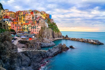 Fototapete Ligurien Stunning view of Manarola village in Cinque Terre National Park, beautiful cityscape with colorful houses and green terraces on cliffs over a sea, Liguria region of Italy. Outdoor travel background