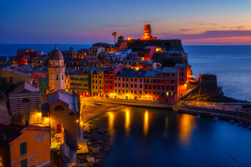 Stunning view of Vernazza village in Cinque Terre National Park, beautiful cityscape with colorful houses, cliffs, sea and a harbor at twilight, Liguria region of Italy. Outdoor travel background