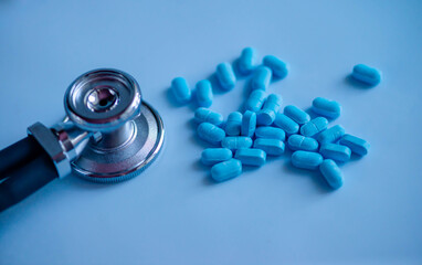 A pile of scattered pills with a stethoscope. Medical background. Medical first aid kit and medicine concept.