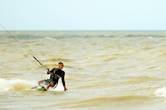 A young kiteboarder rides the waves into the sea
