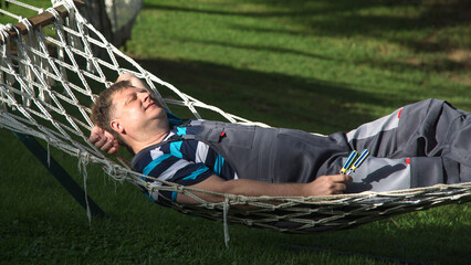 A man rests after work comfortable wicker chair in the garden.