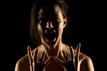 Silhouette of young unhappy screaming woman on black background