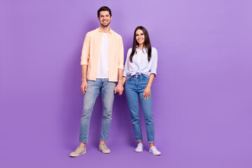 Full size photo of two positive people hold hands toothy smile good mood isolated on violet color background