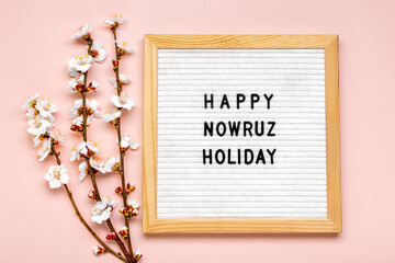 Sprigs of the apricot tree with flowers on pink background Text Happy Nowruz Holiday Concept of spring came Top view Flat lay Hello march, persian new year - 577035928