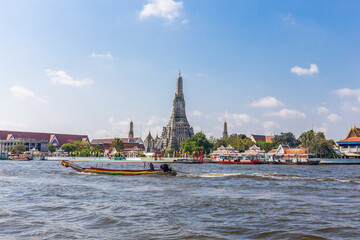 Fototapeta premium Wat Arun with the Chao Phraya River and boats in front is a popular destination for tourists around the world. Bangkok Thailand