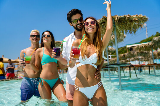 Group of friends together enjoying party, cocktails on summer vacation. People travel fun concept.