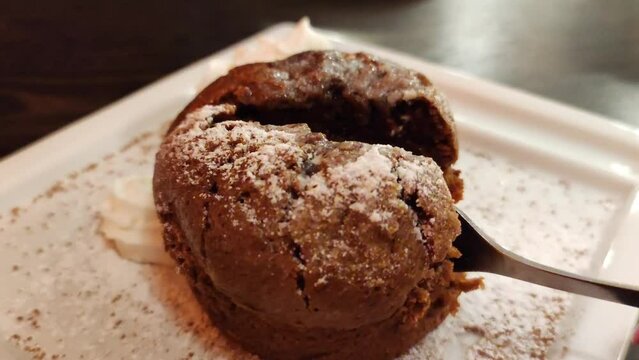 Chocolate cupcake, brownie. Video where the cupcake is cut with a fork. Sweet brownie dessert.