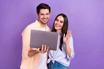 Photo of friendly people young friends wave palm hello online seminar remote hold new laptop internet connection isolated on violet color background