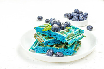 Homemade Belgium Waffles with blueberries. Gluten-free blue dessert, fresh fruits and mint