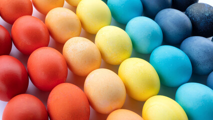 Fototapeta na wymiar Rainbow painted eggs for easter background with copy space. Diagonal pattern with easter eggs closeup. Colored eggs are laid out in a gradient and diagonally on a white background.