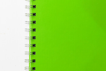 Close-up of a green notebook with checkered pages. Spiral notebook isolated
