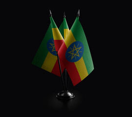 Small national flags of the Ethiopia on a black background