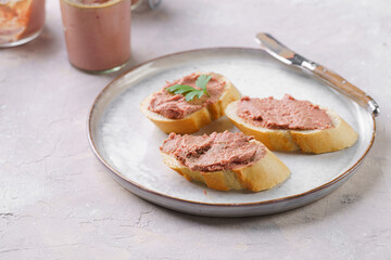 Homemade chicken liver pate on fresh french white wheat baguette slices on wooden plate, glass...