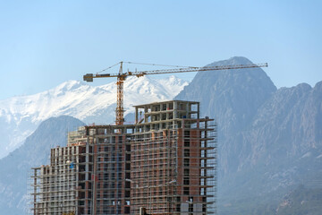 New modern apartment buildings high house with construction crane against the backdrop of mountain...