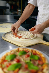 Above view on chef hand preparing pizza base on professional kitchen