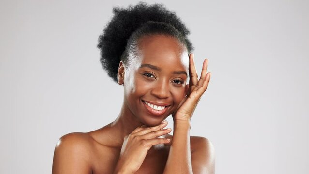 Beauty, portrait and black woman with a glow from skincare isolated on grey studio background. Cosmetic, smile and African girl touching her face for a soft, feminine and clear complexion and mockup