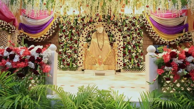A tilt view of the Sai Ram or Sai Baba idol amidst floral decoration