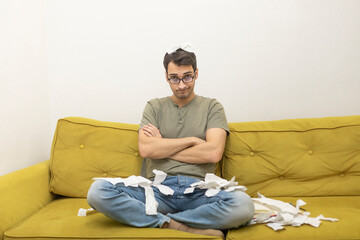 Fototapeta premium Close up of unhappy man sitting on the couch, stressed and confused by calculate expense from invoice or bills, have no money to pay mortgage or loan. High prices and spending money concept