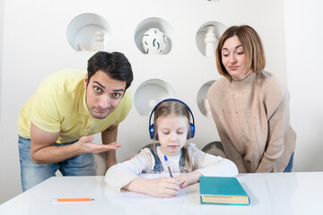 Fototapeta premium Portrait of happy family with child daughter studying at home. Home education and parents support concept