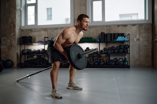 Strong man prepares to lift heavy weights training with barbell