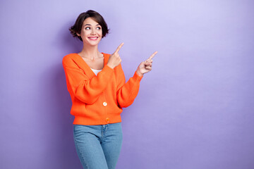 Photo of funky dreamy woman wear orange cardigan looking pointing two fingers empty space isolated...