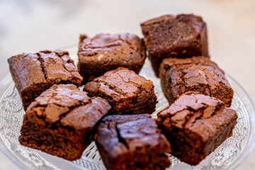 A tempting and delicious chocolate cake cut into squares, served on a crystal plate, perfect for a special occasion celebration