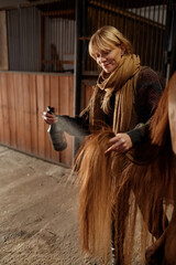Horse owner spraying stallion with conditioner during grooming and cleaning © Nomad_Soul
